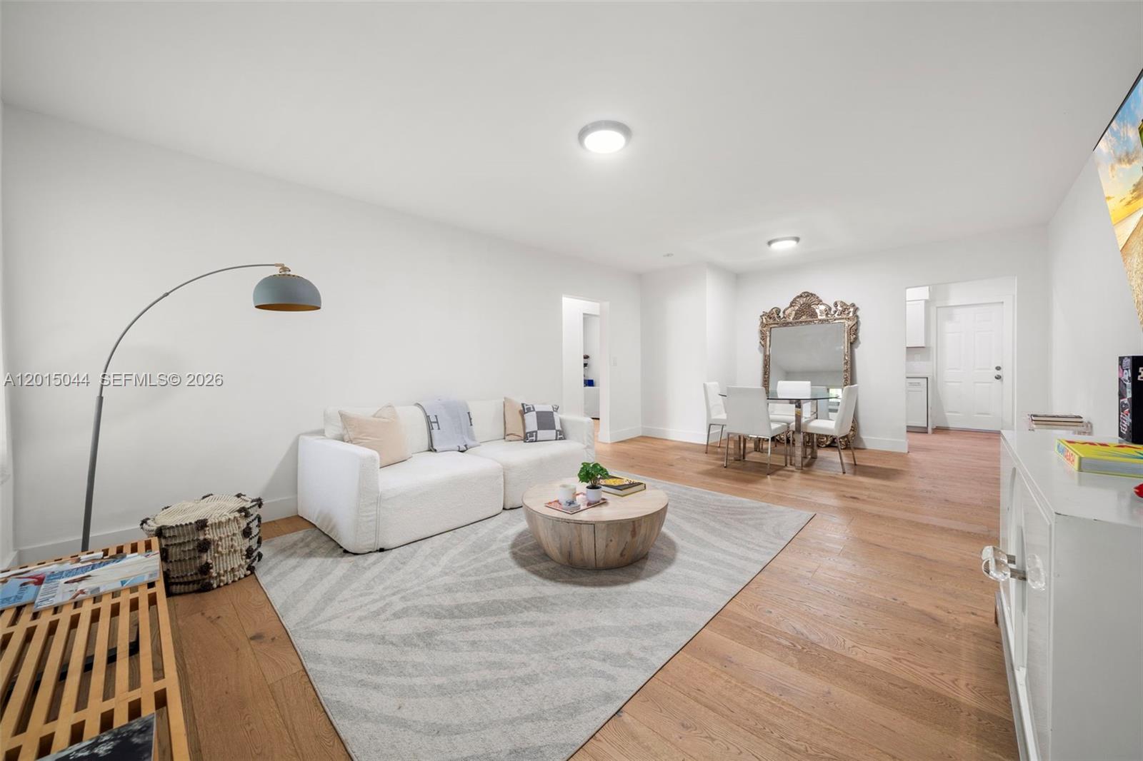 A bright living and dining area features white walls, light wood flooring, and modern furniture — 1125 99th St # 9, Bay Harbor Islands FL 33154, BAY HARBOR ISLANDS, FL