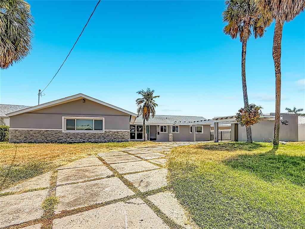A single-story house with a stone facade and a concrete driveway under a clear sky — 7905 11TH AVENUE S, ST PETERSBURG, FL