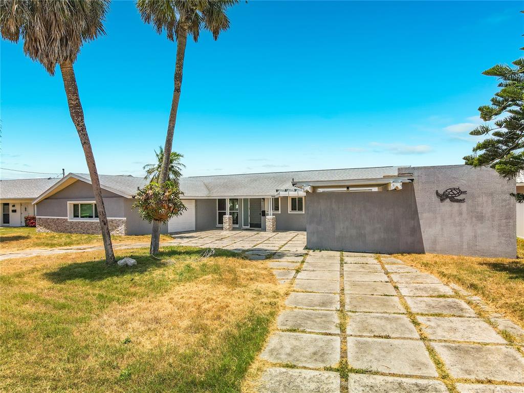 A single-story house with a paved driveway, palm trees, and a turtle wall decoration — 7905 11TH AVENUE S, ST PETERSBURG, FL