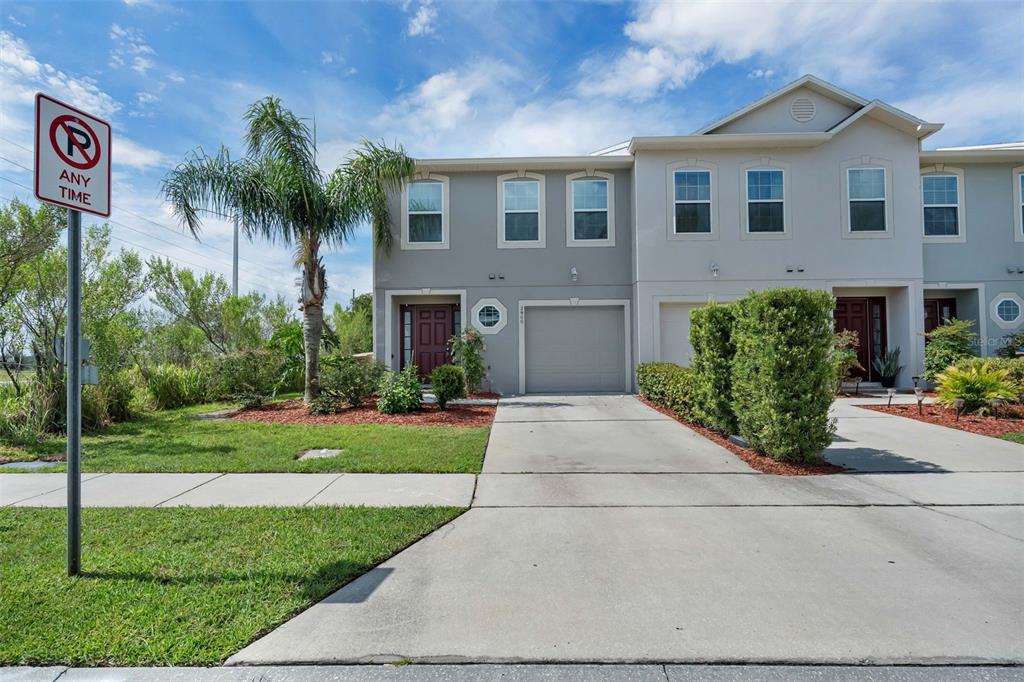 A two-story townhouse with a gray facade, a single-car garage, and a concrete driveway — 2900 CLARABELLE COURT, KISSIMMEE, FL