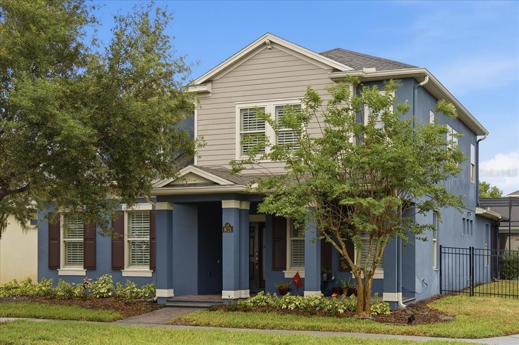 A two-story blue house with a front porch and tan horizontal siding on the upper level — 8721 BAYVIEW CROSSING DRIVE, WINTER GARDEN, FL