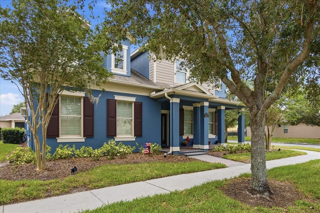 A two-story blue house with dark shutters, a front porch, and a sidewalk in front — 8721 BAYVIEW CROSSING DRIVE, WINTER GARDEN, FL
