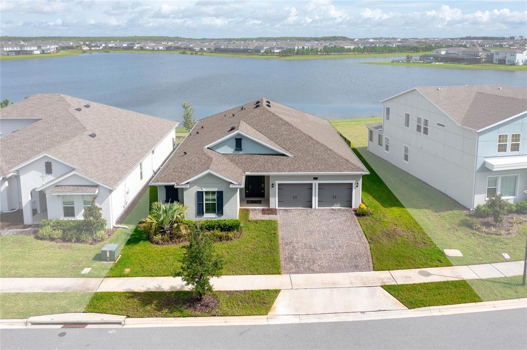 An aerial view of a single-story house with a two-car garage facing a lake — 18405 MOWRY COURT, ORLANDO, FL