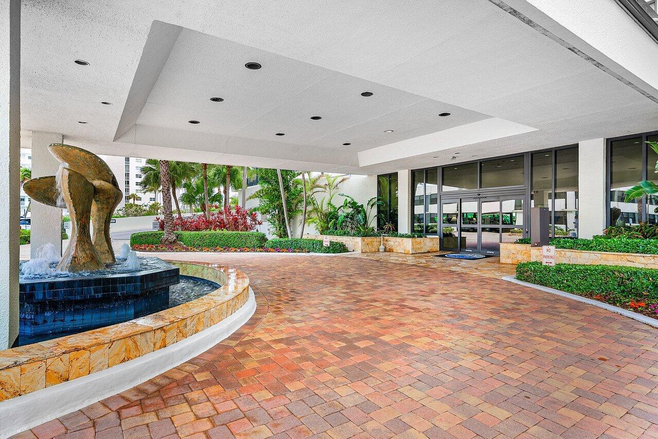 A paved driveway leads to a building entrance featuring a fountain and a covered portico — 3400 S Ocean Boulevard # 5k, Highland Beach FL 33487, HIGHLAND BEACH, FL