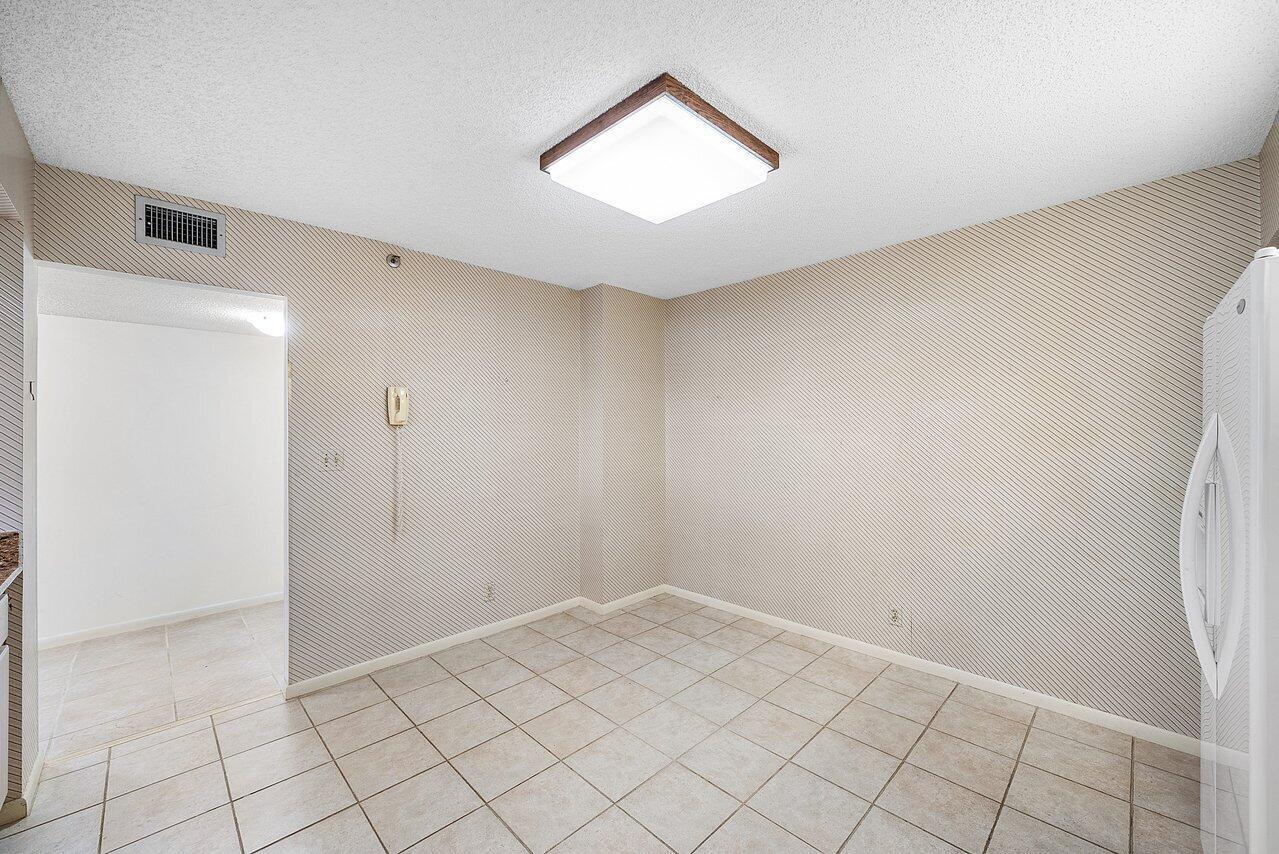 A small dining area features beige diagonal-patterned wallpaper, light tile flooring, and a square light — 3400 S Ocean Boulevard # 5k, Highland Beach FL 33487, HIGHLAND BEACH, FL