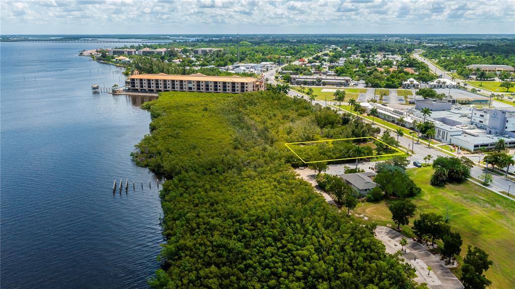 An aerial view shows a rectangular plot of land outlined in yellow near a waterfront — 806 E MARION AVENUE, PUNTA GORDA, FL