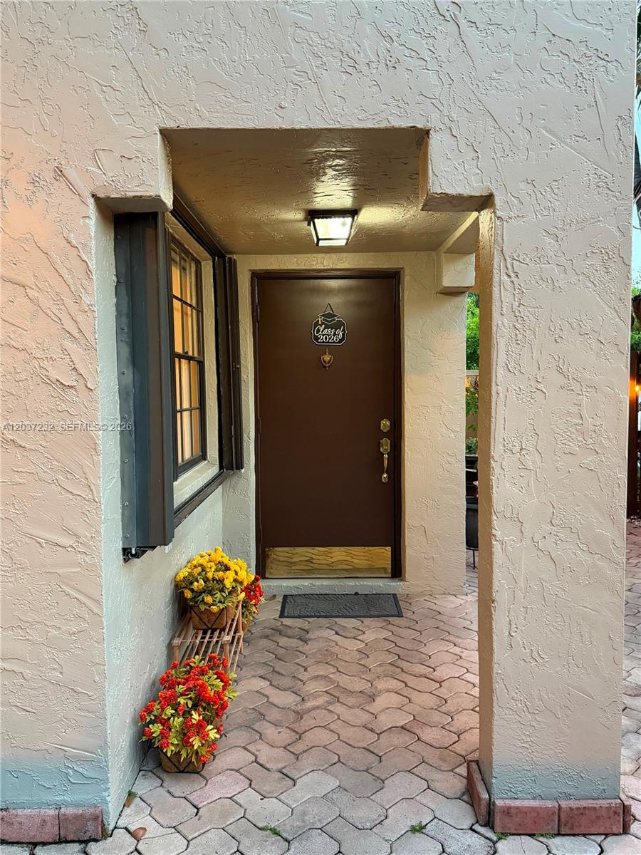 A brown front door with a Class of 2026 sign sits under a covered entryway — 10445 SW 154th Ct # 1, Miami FL 33196, MIAMI, FL