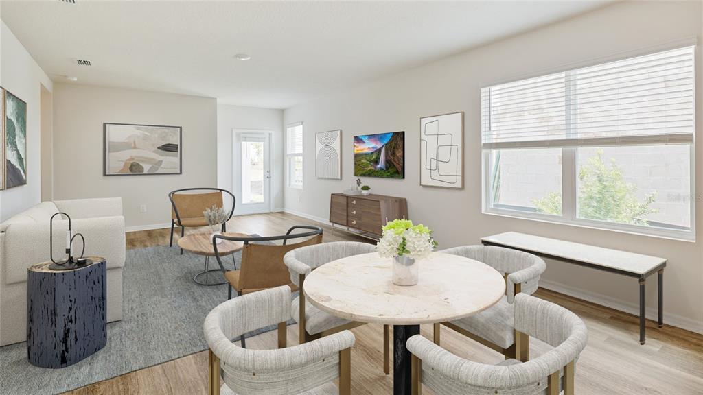 A bright living and dining area features light wood flooring, neutral walls, and modern furniture — 8828 CLEAR VIEW STREET, PARRISH, FL
