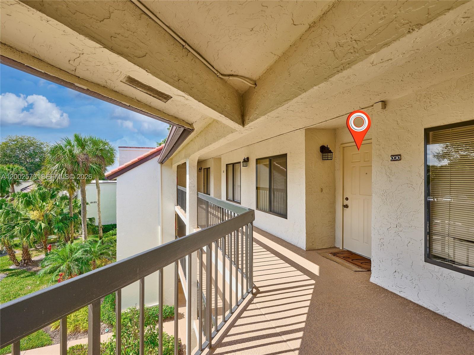 An exterior walkway leads to the entrance of a third-floor apartment unit — 10143 Mangrove Dr # 303, Boynton Beach FL 33437, BOYNTON BEACH, FL