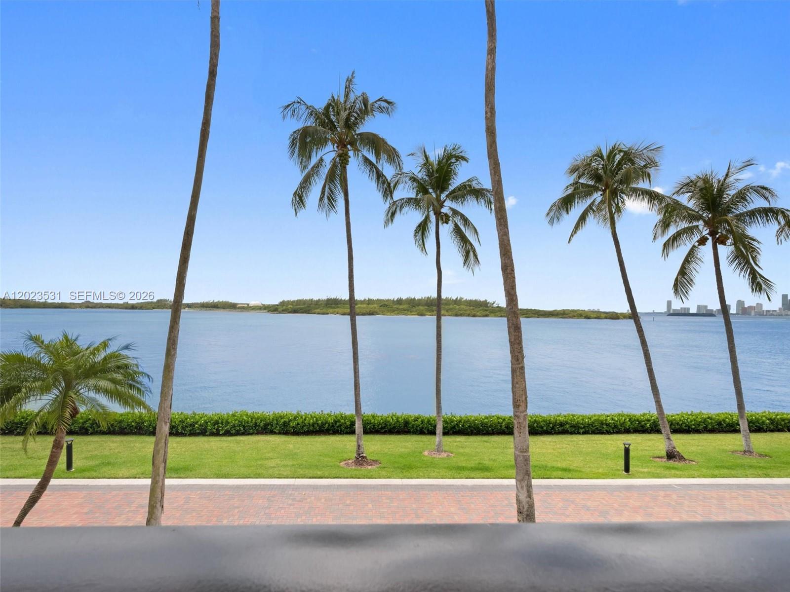 A view of a grassy lawn, palm trees, and a body of water — 2425 Fisher Island Dr # 5205, Miami Beach FL 33109, MIAMI BEACH, FL