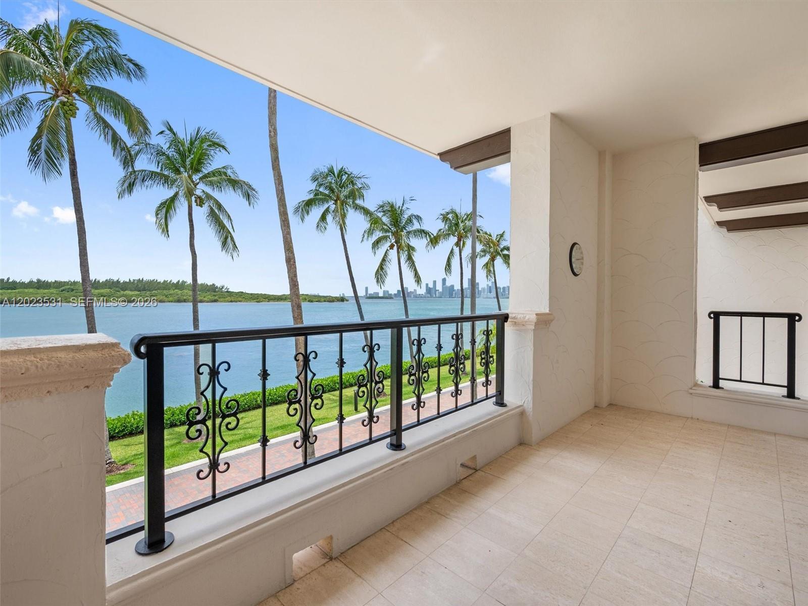A covered balcony features a decorative metal railing, tile flooring, and a waterfront view — 2425 Fisher Island Dr # 5205, Miami Beach FL 33109, MIAMI BEACH, FL