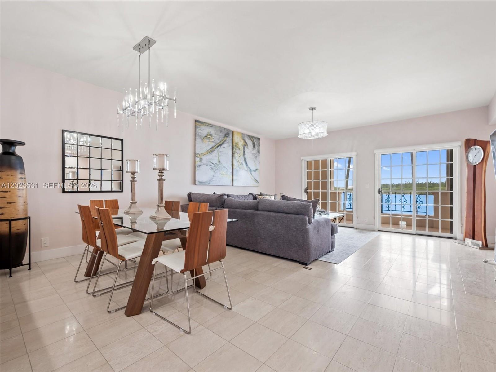 A dining and living area features tile floors, a glass table, and sliding glass doors — 2425 Fisher Island Dr # 5205, Miami Beach FL 33109, MIAMI BEACH, FL