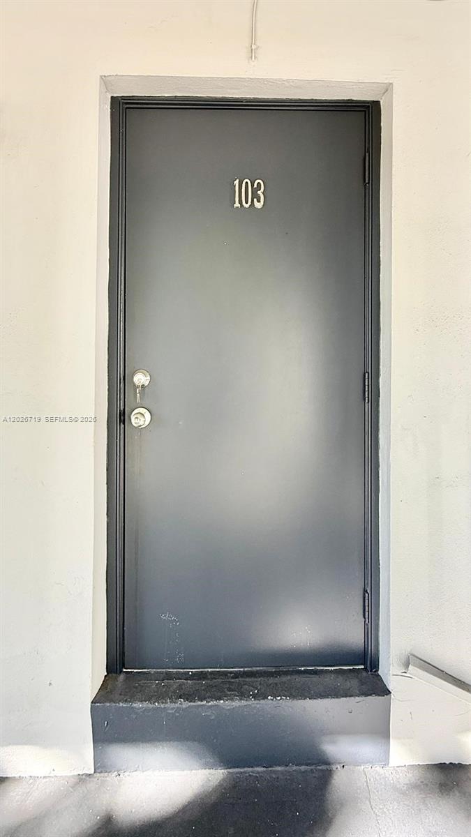 A dark gray metal door with the number 103 is set in a white wall — 42 SW 14th St # 103, Dania Beach FL 33004, DANIA BEACH, FL