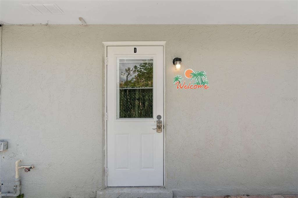A white exterior door labeled D features a glass panel and a digital keypad lock — 11953 DE LEON DRIVE, NORTH PORT, FL