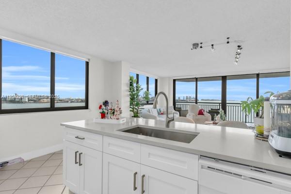 A kitchen island with a sink overlooks a living area and a waterfront balcony view — 540 Brickell Key Dr # 832, Miami FL 33131, MIAMI, FL