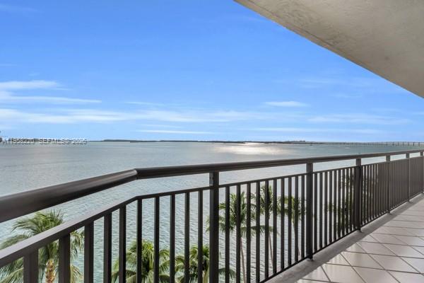 A balcony with a metal railing overlooks a large body of water and palm trees — 540 Brickell Key Dr # 832, Miami FL 33131, MIAMI, FL