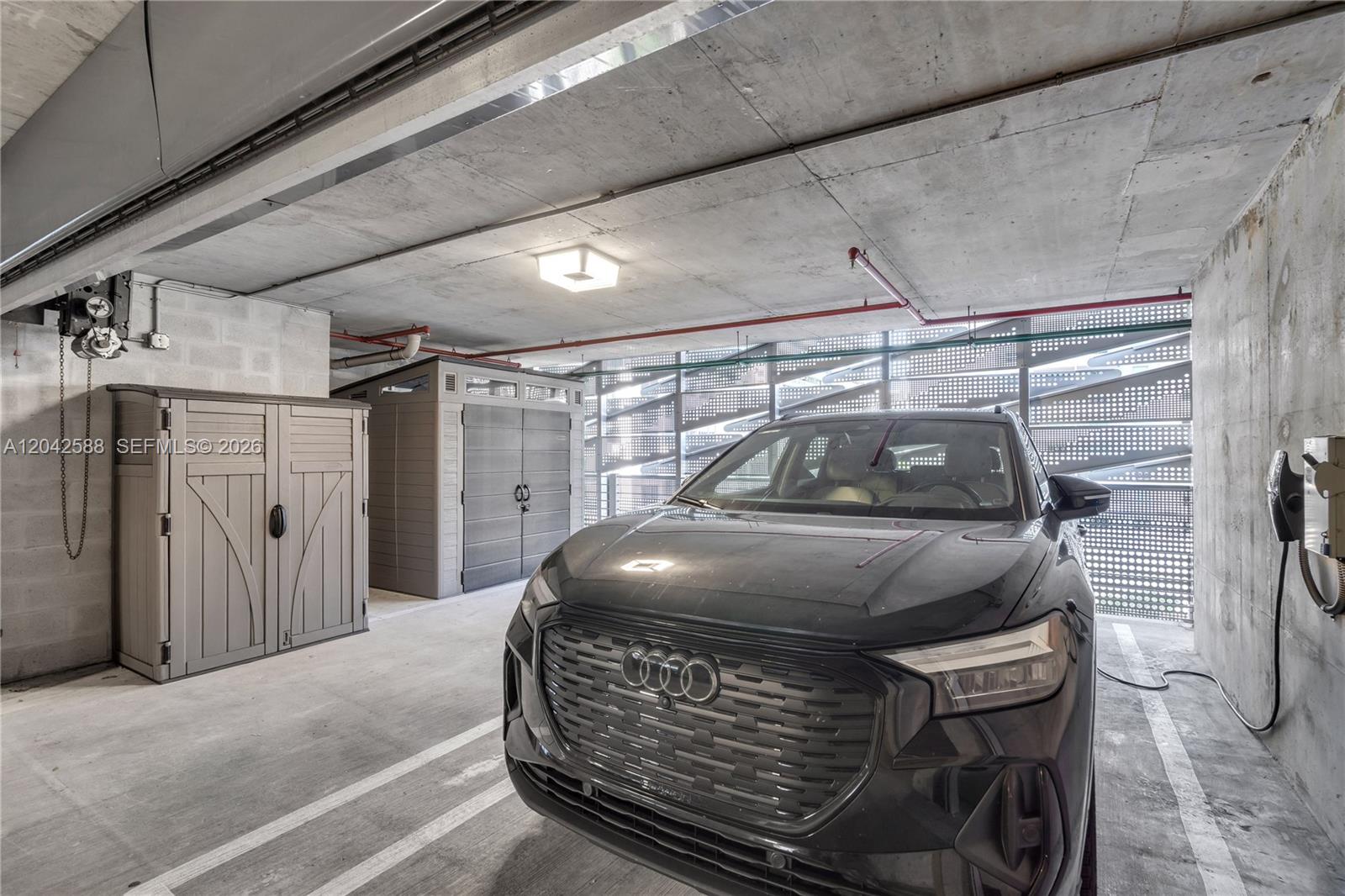 A dark Audi SUV is parked in a concrete garage with two plastic storage sheds — 1000 Brickell Plz # 2402, Miami FL 33131, MIAMI, FL