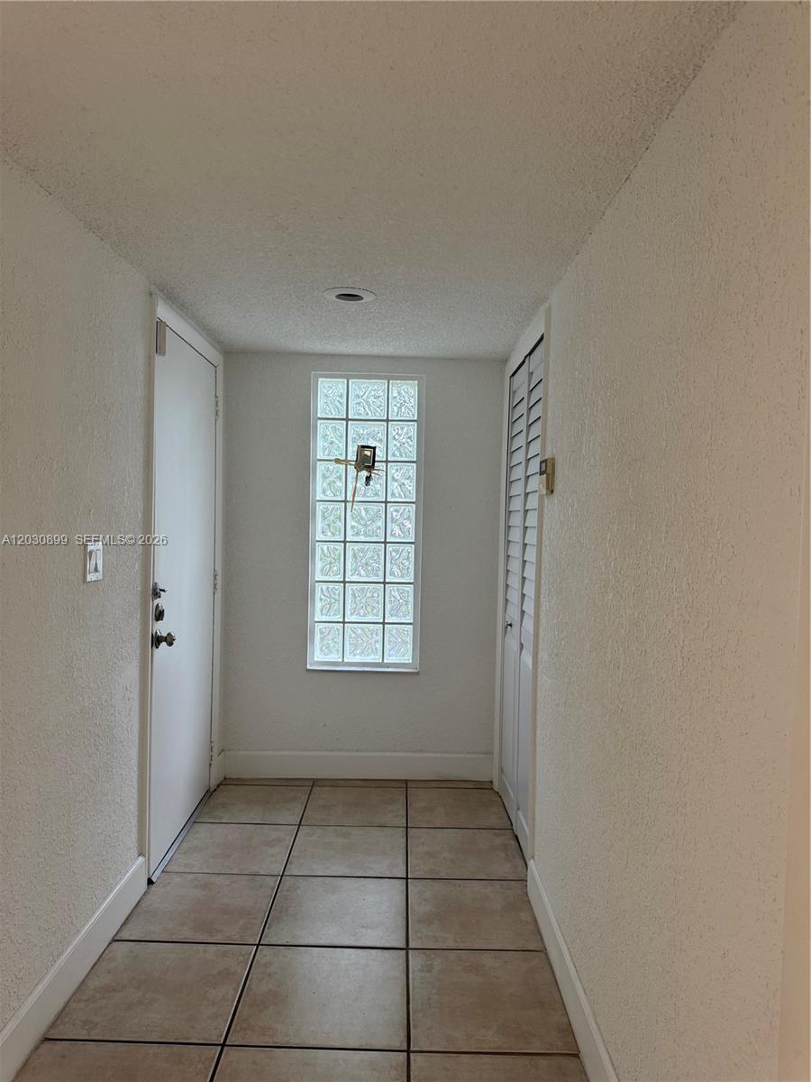 A tiled entryway features a white door, a louvered closet door, and a glass block window — 16184 Laurel Dr # 204, Weston FL 33326, WESTON, FL