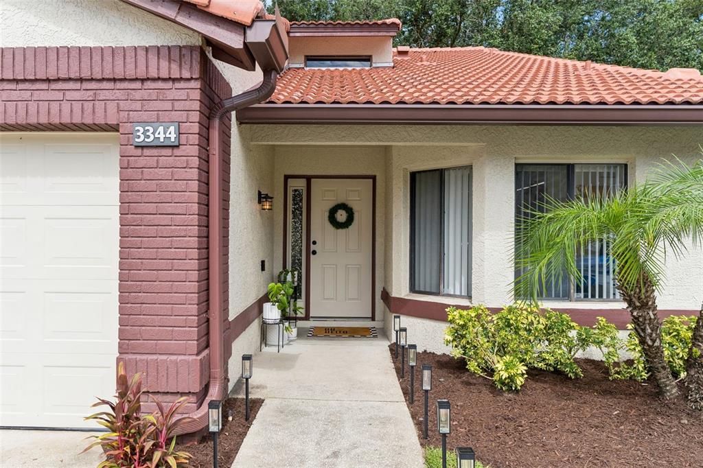 A front exterior view of a house with a brick facade, tiled roof, and walkway — 3344 GRAY FOX COVE UNIT 4, APOPKA, FL