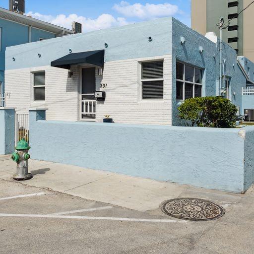 A light blue and white single-story building with a black awning and a fire hydrant — 301 Van Buren Street # 101d, Hollywood FL 33019, HOLLYWOOD, FL