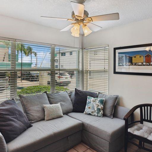A living room features a gray sectional sofa, a ceiling fan, and large corner windows — 301 Van Buren Street # 101d, Hollywood FL 33019, HOLLYWOOD, FL