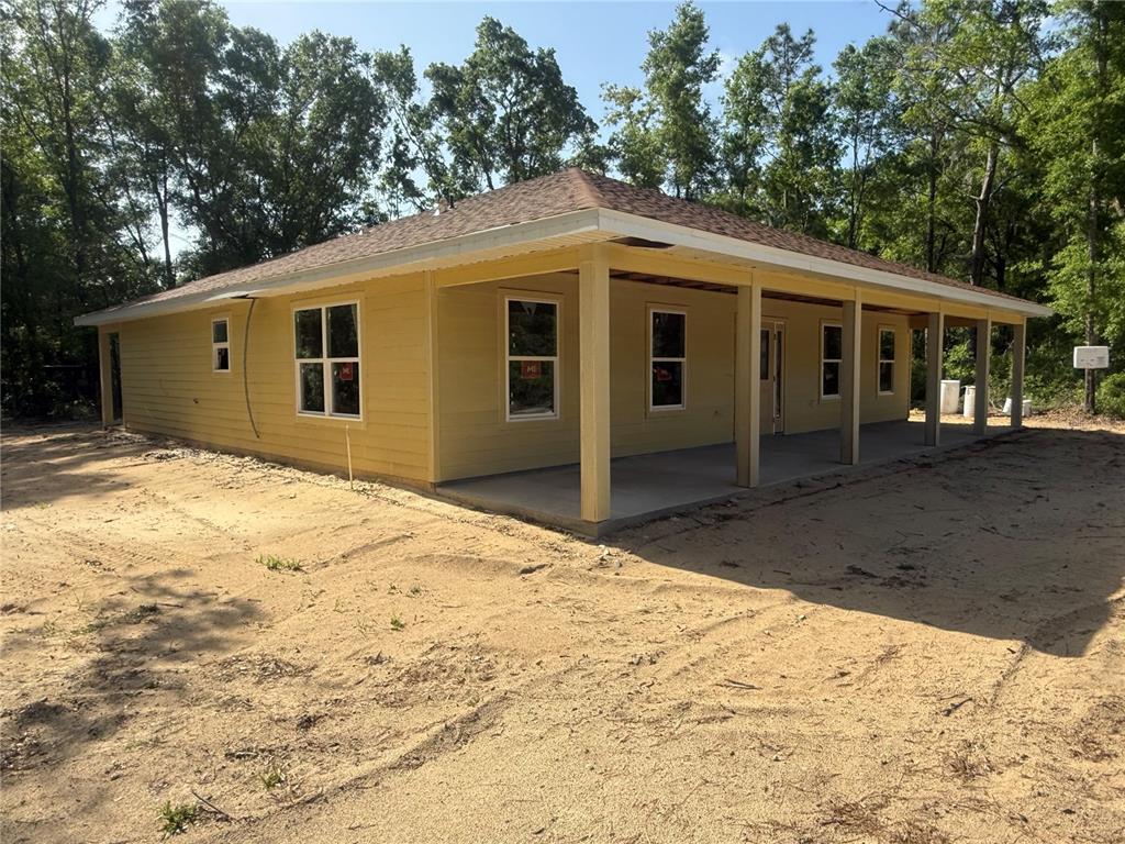 A yellow, single-story house under construction features a covered porch and a hip roof — 551 NE STATE ROAD 121, WILLISTON, FL