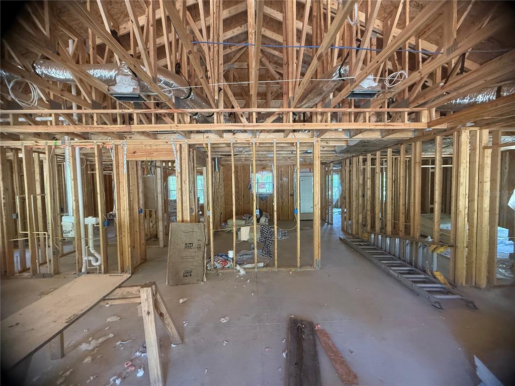 An interior view of a house under construction with exposed wooden framing and ductwork — 551 NE STATE ROAD 121, WILLISTON, FL