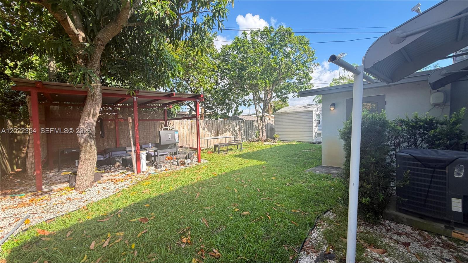 A backyard features a covered patio area, a grassy lawn, and a small storage shed — 3610 SW 39th Ave, West Park FL 33023, WEST PARK, FL