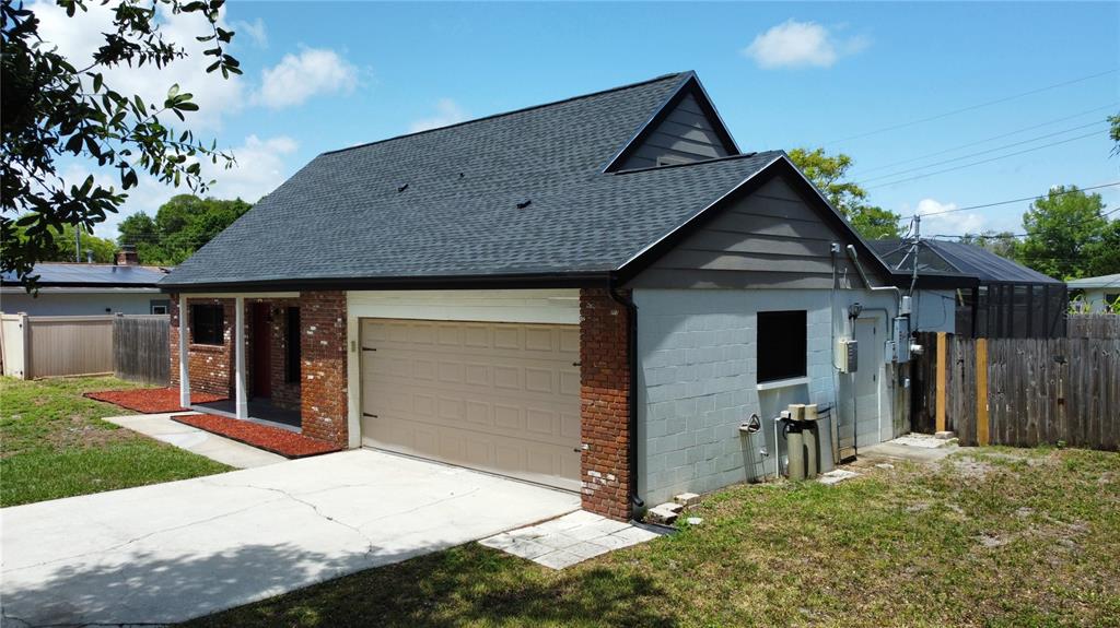 A detached garage with a brick and concrete block exterior and a dark shingled roof — 1804 PONDEROSA LANE, TITUSVILLE, FL