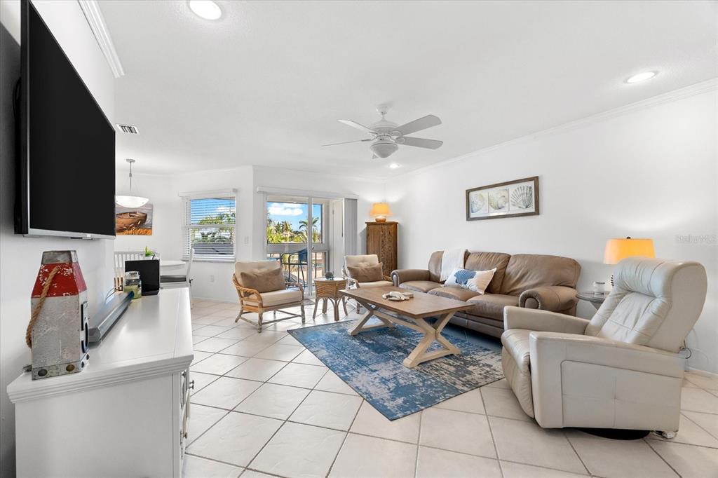 A living room features tile floors, a ceiling fan, a sofa, and a sliding door — 6708 SARASEA CIRCLE UNIT 202, SARASOTA, FL