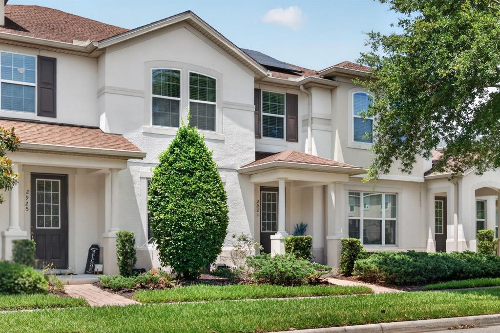 The exterior of a multi-unit residential building features stucco walls, brown shutters, and shingled roofs — 2921 CELLO LANE, KISSIMMEE, FL