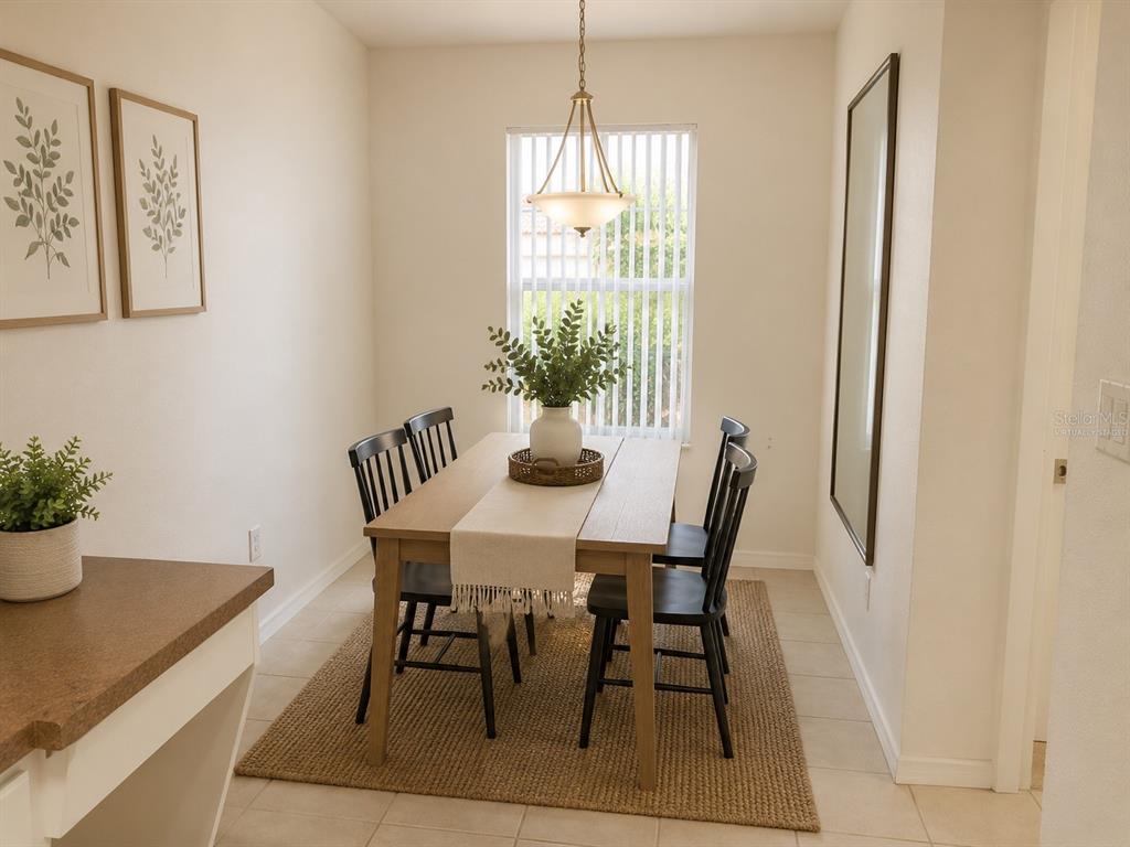 A dining room features a wooden table with four black chairs on a woven rug — 5001 SUNRIDGE PALMS DRIVE, TAMPA, FL