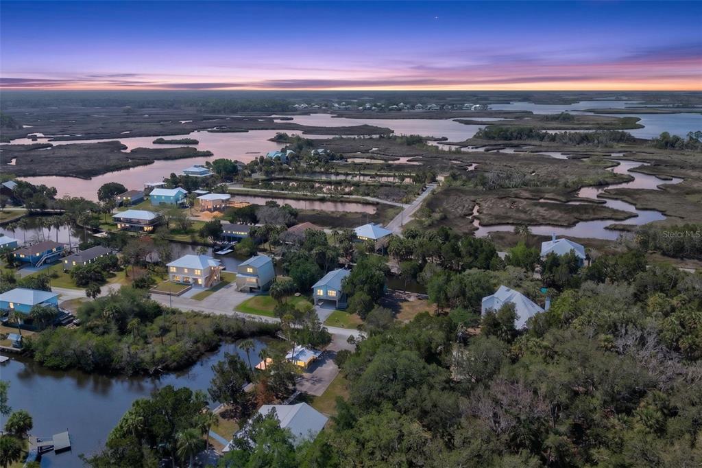 An aerial view shows several houses situated among coastal marshlands and waterways at sunset — 12122 W GULF BREEZE COURT, CRYSTAL RIVER, FL