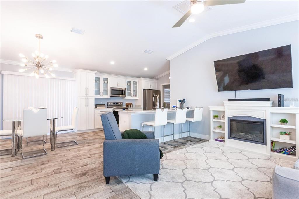 An open-concept living area features a kitchen with white cabinetry, a fireplace, and dining space — 691 E COUNTRY CLUB DRIVE, WILLISTON, FL