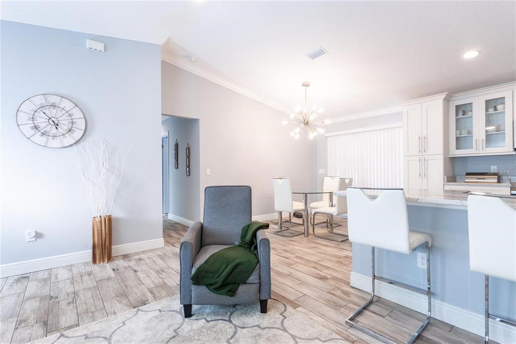 A gray armchair sits on a patterned rug in a room with light wood flooring — 691 E COUNTRY CLUB DRIVE, WILLISTON, FL