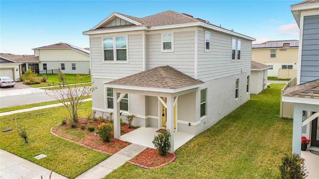 A two-story house with light-colored siding, a covered front porch, and a shingled roof — 1823 SUMMER SERENITY DRIVE, KISSIMMEE, FL
