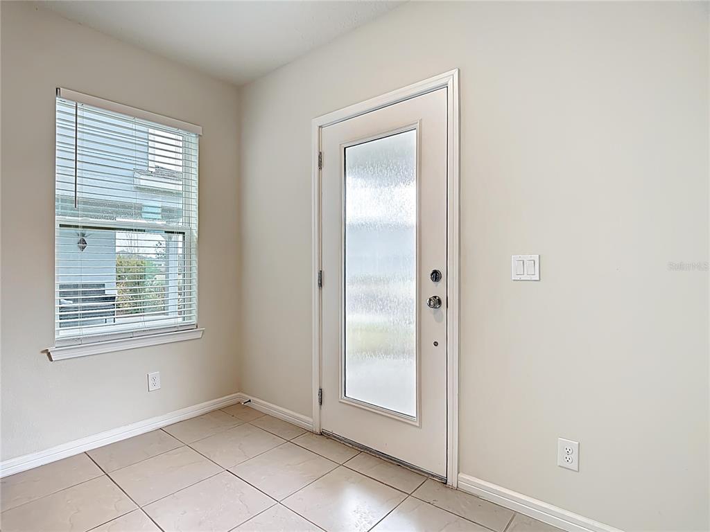 An entryway with tile flooring, a window with blinds, and a white door with glass — 1823 SUMMER SERENITY DRIVE, KISSIMMEE, FL