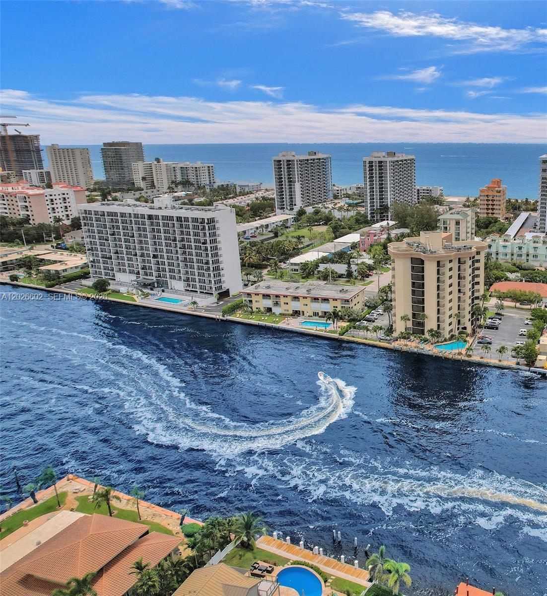 An aerial view shows a coastal waterway with a boat and several residential apartment buildings — 501 N Riverside Dr, Pompano Beach FL 33062, POMPANO BEACH, FL