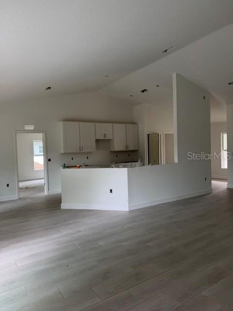 A bright, empty room features light wood-look tile flooring, white walls, and a sliding glass door — 3036 THORNHILL ROAD, WINTER HAVEN, FL