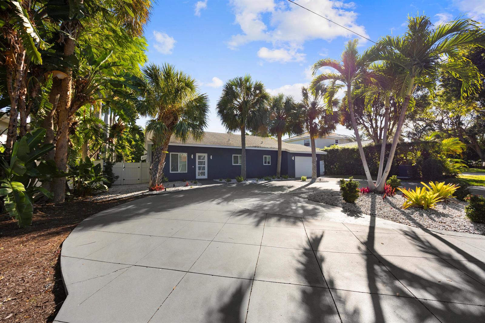 A dark blue house with a large concrete driveway and palm trees in the front yard — 930 NW 4th Court, Boca Raton FL 33432, BOCA RATON, FL