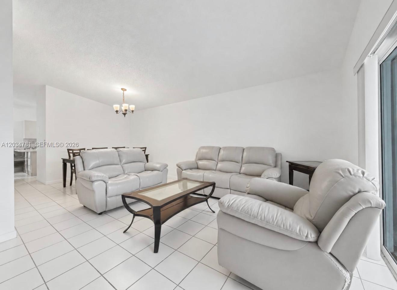 A living room features white tile flooring, light gray leather furniture, and a glass coffee table — 7611 SW 153rd Ct # 204, Miami FL 33193, MIAMI, FL