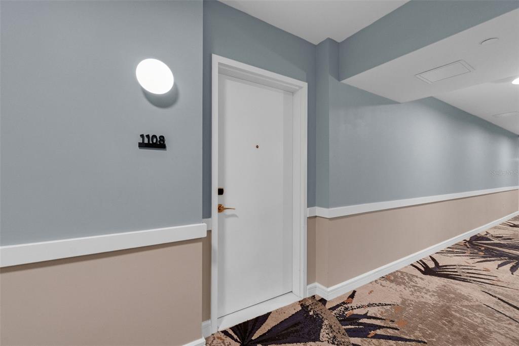A white door with the number 1108 is set in a hallway with two-toned walls — 3151 SUNSET WALK DRIVE UNIT 1108, KISSIMMEE, FL
