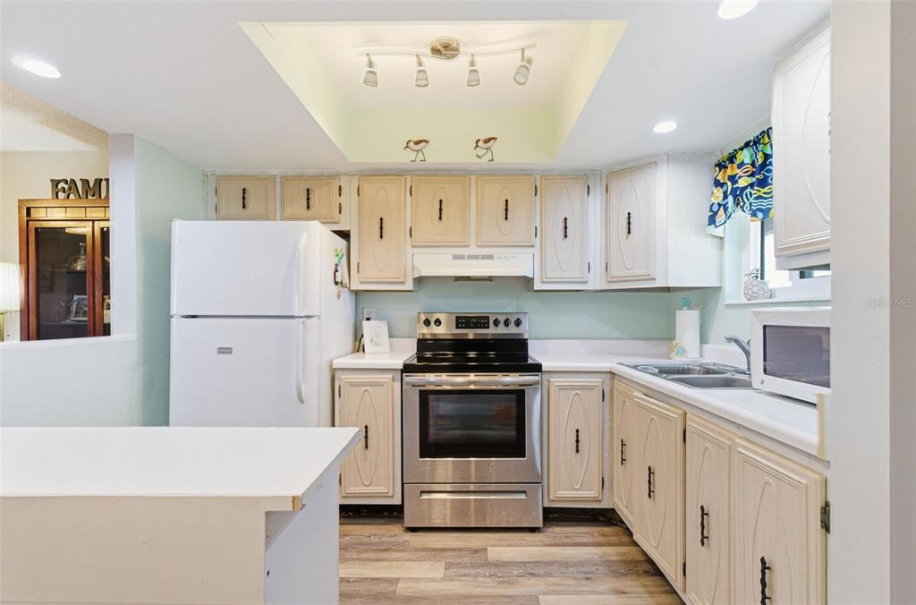 A kitchen features light-colored cabinets, stainless steel appliances, and a recessed ceiling light fixture — 801 83RD AVENUE N UNIT 510, ST PETERSBURG, FL
