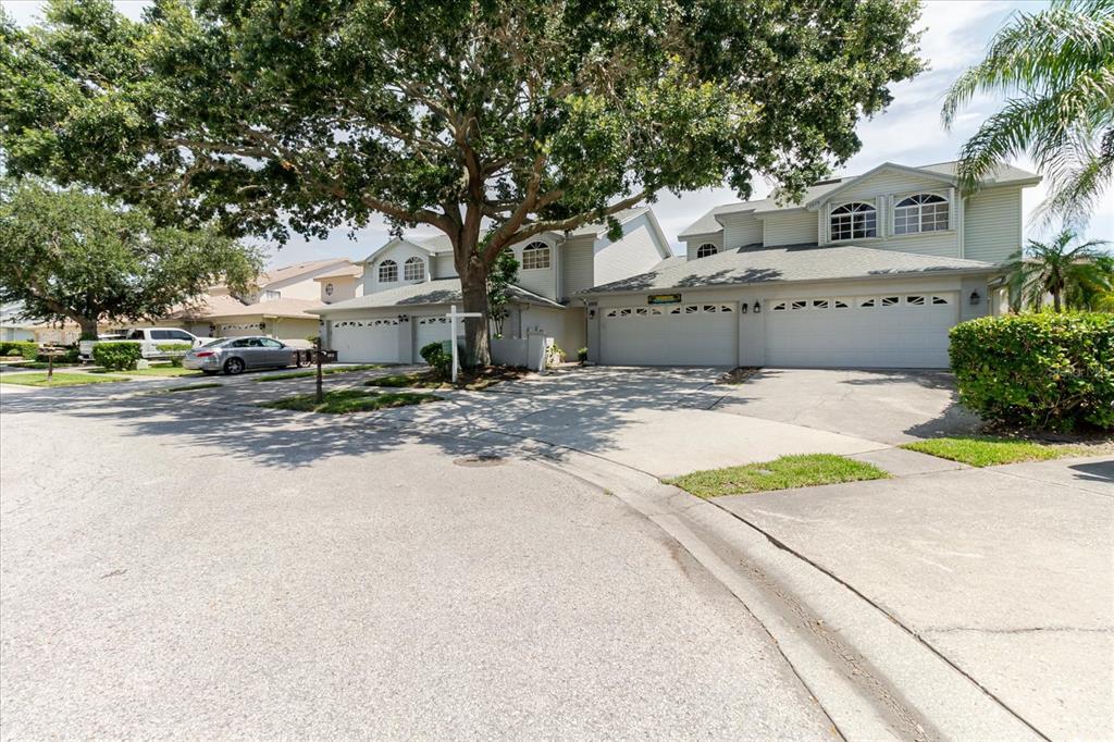 A two-story suburban house with a multi-car garage and a large tree in the front — 2976 FIELDBROOK PLACE, CLEARWATER, FL