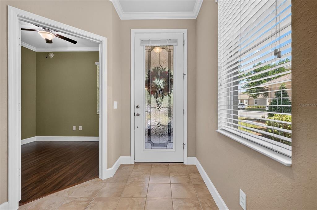 An entryway features tan walls, tile flooring, a decorative glass front door, and a side window — 9137 SW 70TH LOOP, OCALA, FL
