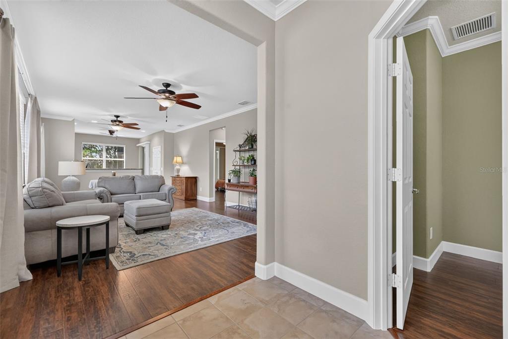 A view from a tiled entryway into a living room with wood floors and furniture — 9137 SW 70TH LOOP, OCALA, FL