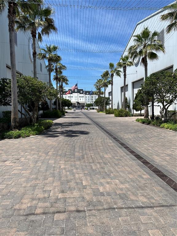 A paved walkway lined with palm trees leads toward a building with an American flag — 00 W HWY 40, LOT 11, OCALA, FL