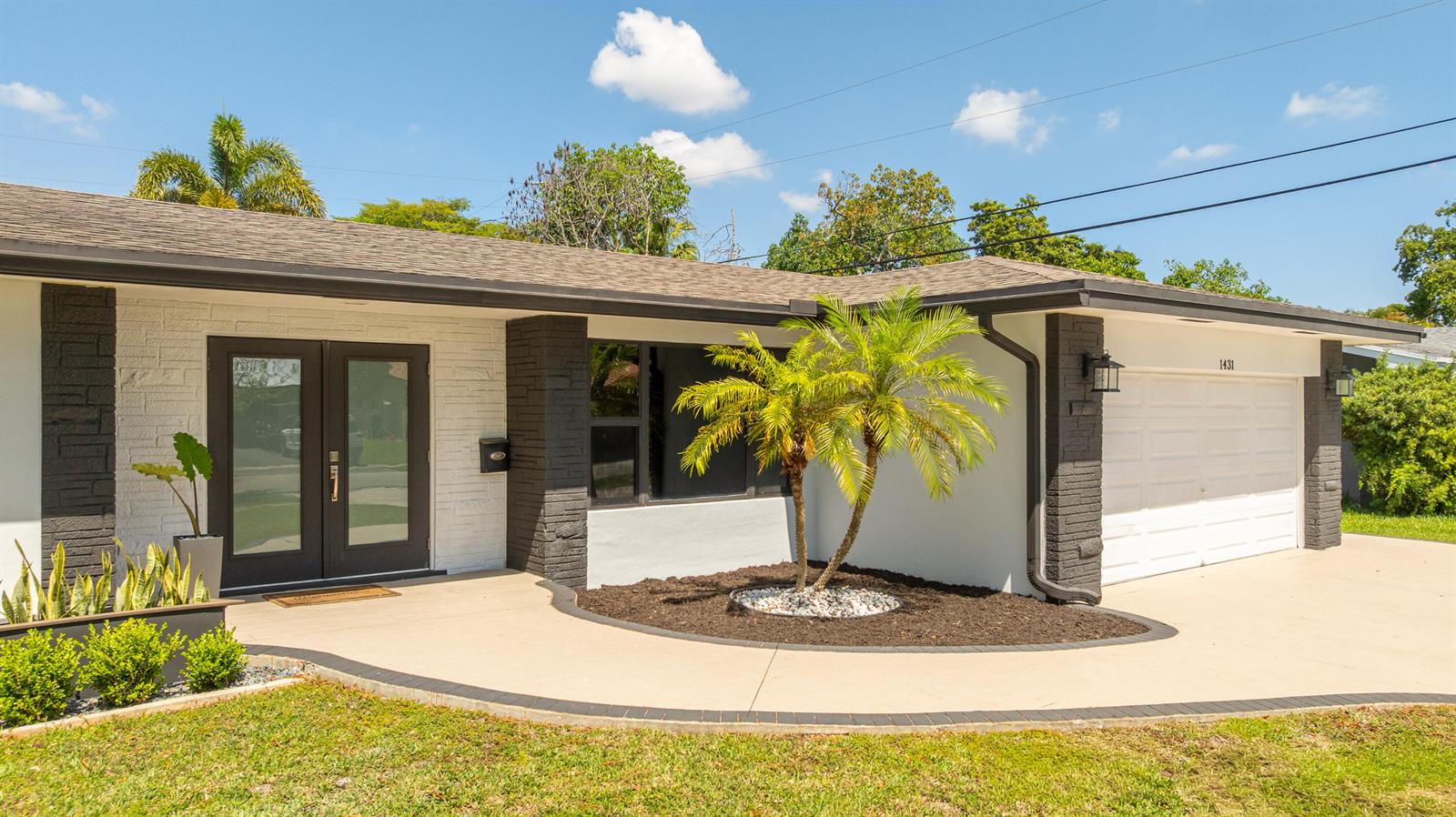 A single-story house with a white brick facade, dark trim, double front doors, and a garage — 1431 NW 70th Way, Plantation FL 33313, PLANTATION, FL