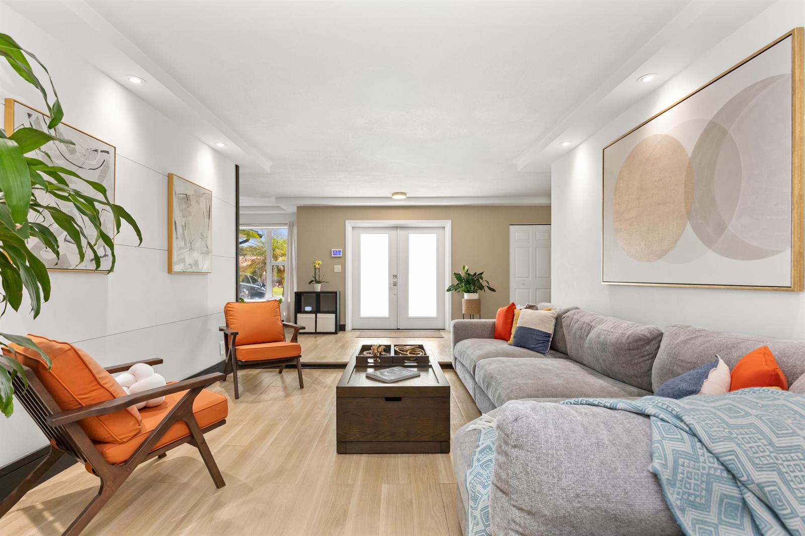 A living room features a gray sectional sofa, two orange armchairs, and light wood flooring — 1431 NW 70th Way, Plantation FL 33313, PLANTATION, FL