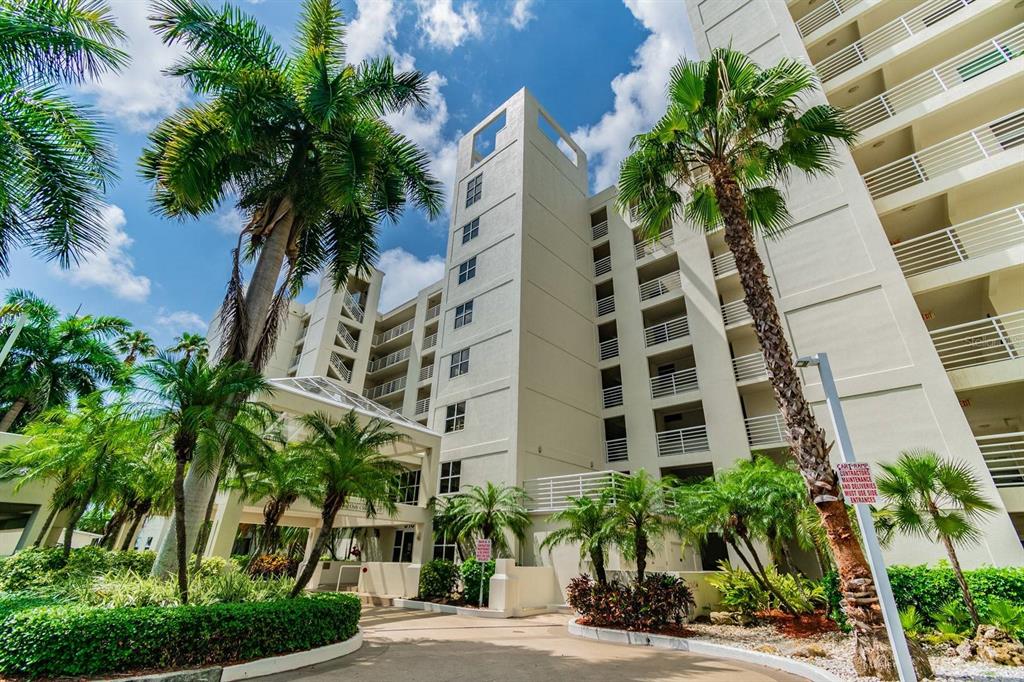 A multi-story white apartment building exterior features palm trees and a paved entrance driveway — 6105 BAHIA DEL MAR CIRCLE UNIT 287, ST PETERSBURG, FL